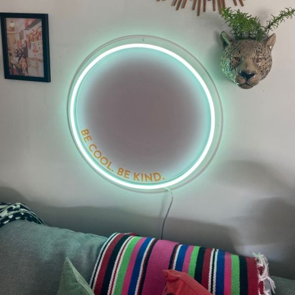 Be Cool Be Kind Mint Pink & Orange Neon Art shown turned on, wall mounted above a sofa @customneon Signs of Change charity range
