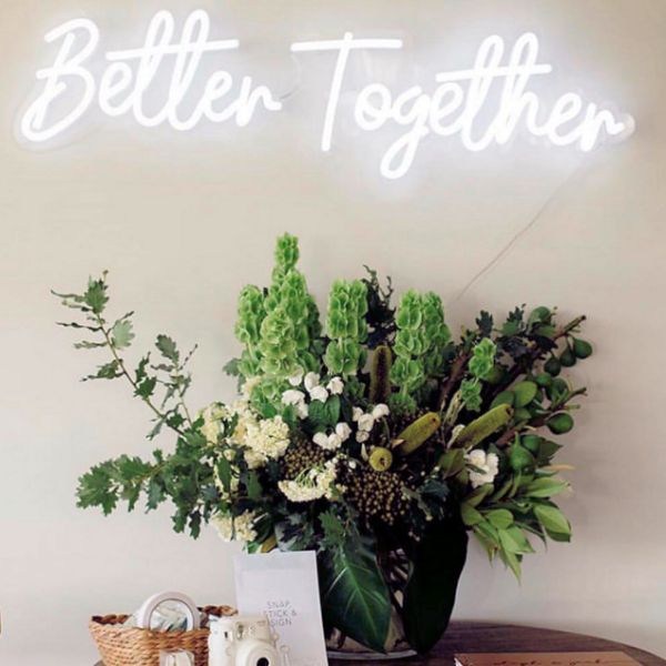 Better Together neon wedding sign wall mounted above the wedding photo table - photo from CustomNeon.com