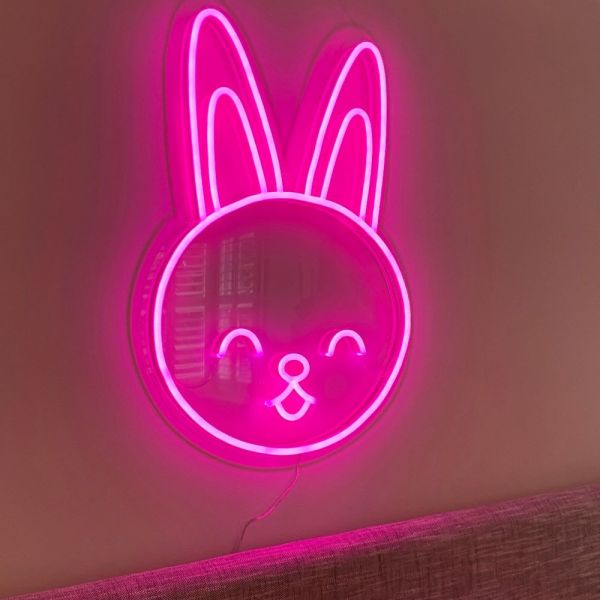 Custom Neon® pink bunny face shown as wall art in a living room
