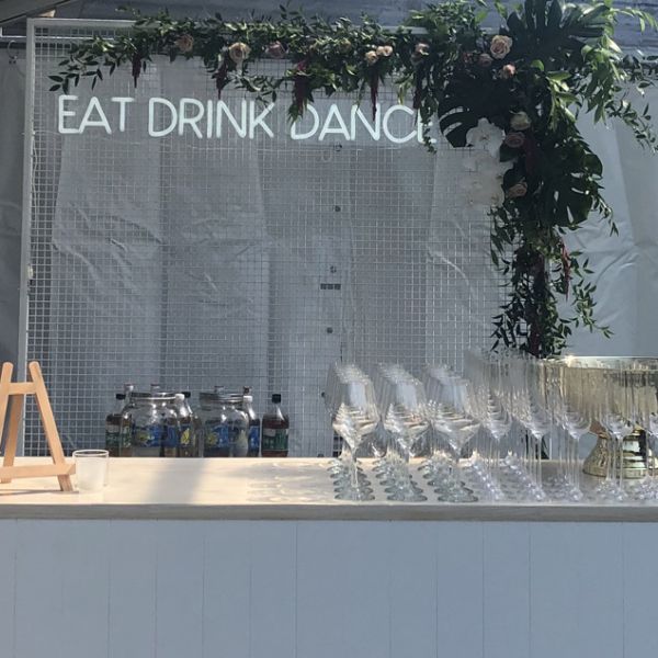 EAT DRINK DANCE neon flex sign shown behind a pop up event bar - photo from CustomNeon.co.uk
