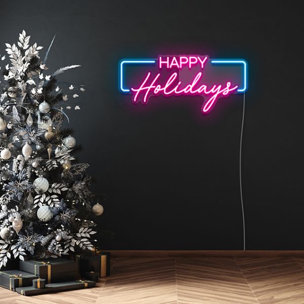 Pink & Blue Happy Holidays Sign by CUSTOM NEON® shown on dark wall next to a monochrome Christmas tree