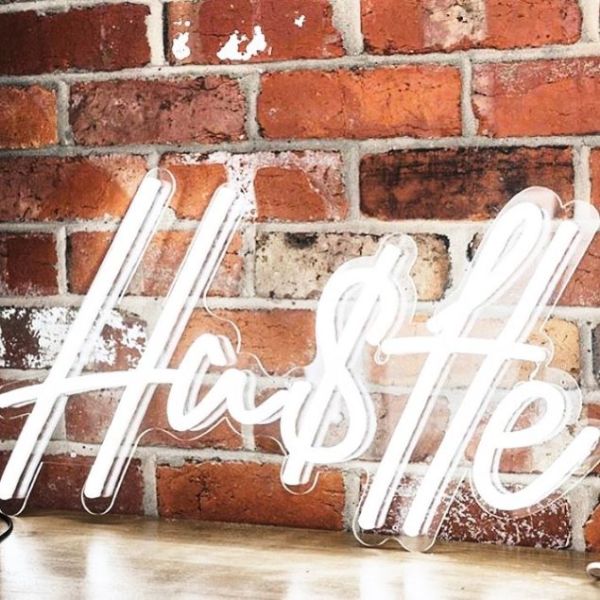 Hustle light sign against an exposed brick wall  - from Custom Neon
