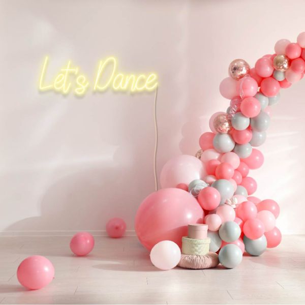 Let's Dance neon party sign in LED flex shown wall mounted near a balloon arch - from Custom Neon®