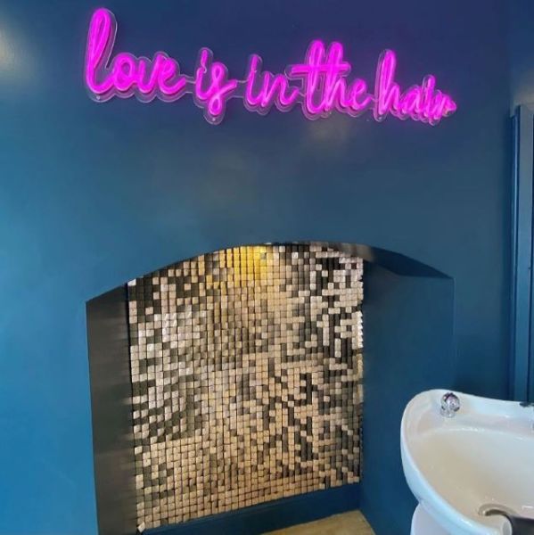 Love is in the hair dark pink LED neon word sign shown turned off @blushsalon.uk by @customneon