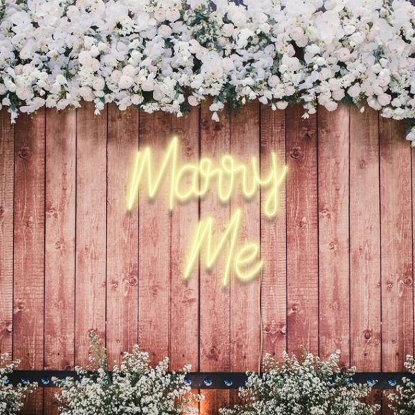 Marry Me neon flex wedding sign in warm white on a wooden fence - from Custom Neon