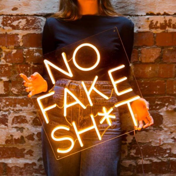 No Fake Shit LED light sign shown against a brick wall - by Custom Neon