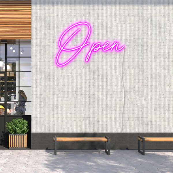 CUSTOM NEON® Pink LED Open sign shown ina script font, wall mounted on the outside of a building