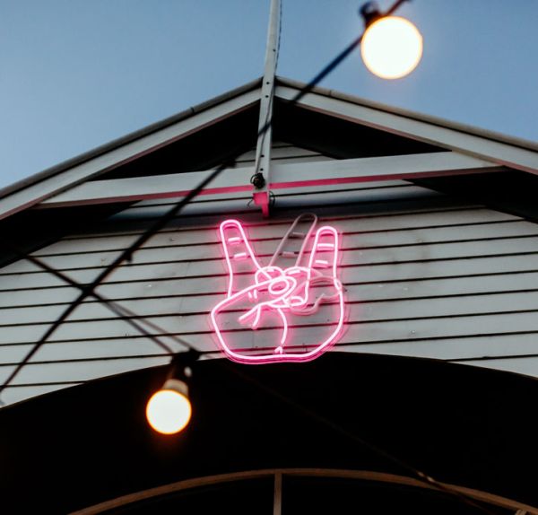 neon sign that alternates between the peace sign and sign of the horns - photos CustomNeon.com