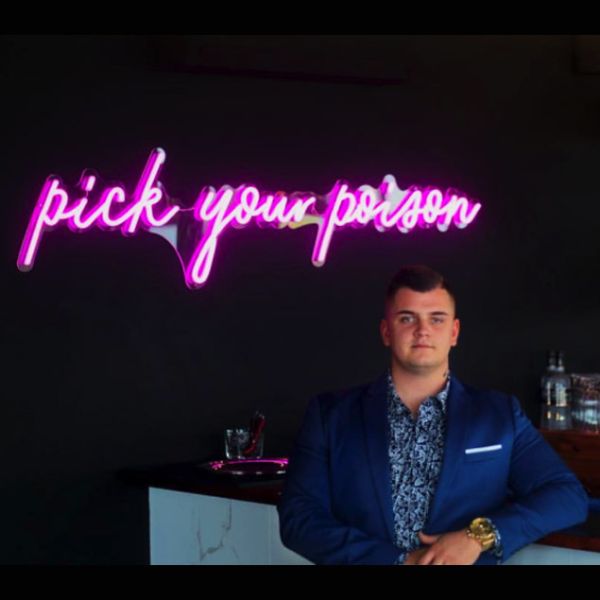Pick Your Poison LED Neon Bar Sign shown above the bar at a party - from CustomNeon.com