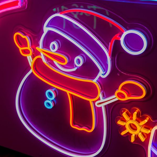 Custom Neon® snowman in bright white and warm white LED neon flex shown illuminated against a dark background in dim light