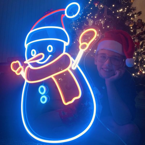 Custom Neon® snowman lightup decoration in front of a Christmas tree