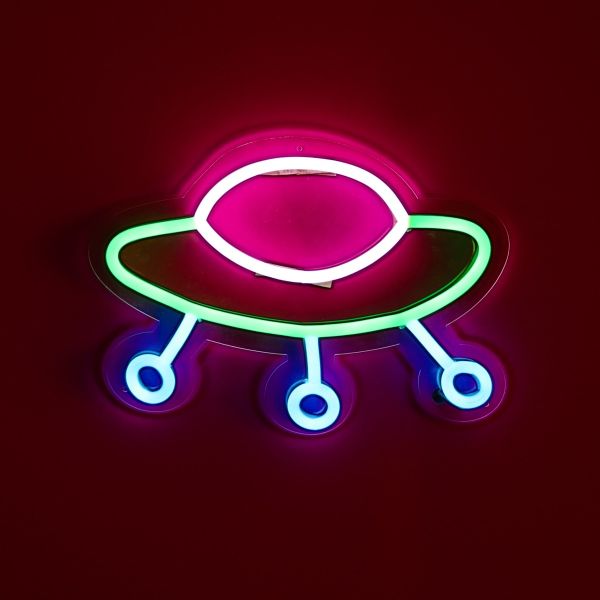 Retro Spaceship LED neon art from Custom Neon®. Shown illuminated against a dark pink wall in dim lighting.