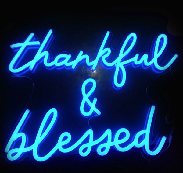 Thankful & Blessed LED Neon Sign - cursive word sign on a clear acrylic backboard - photo from CustomNeon.co.uk
