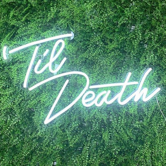 Til Death Neon Sign in LED flex shown in bright white on a green wall - photo CustomNeon.com