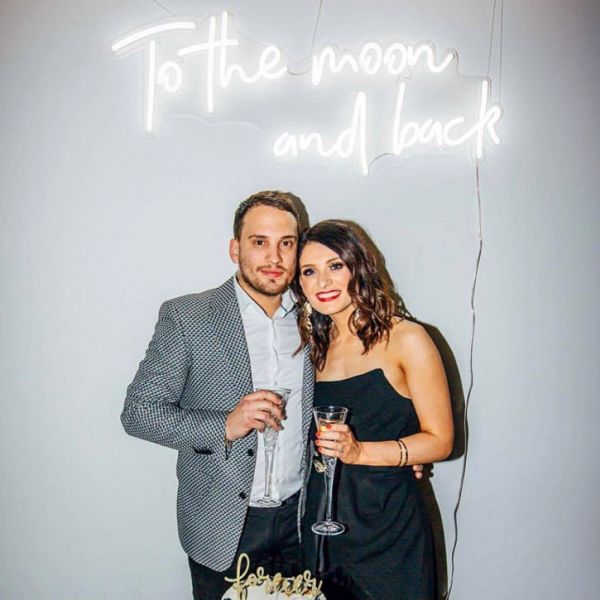To the Moon and Back light up sign, shown as a wedding backdrop - photo from CustomNeon.com