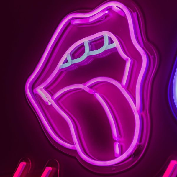 Custom Neon® pink tongue shown illuminated against a dark background in dim light