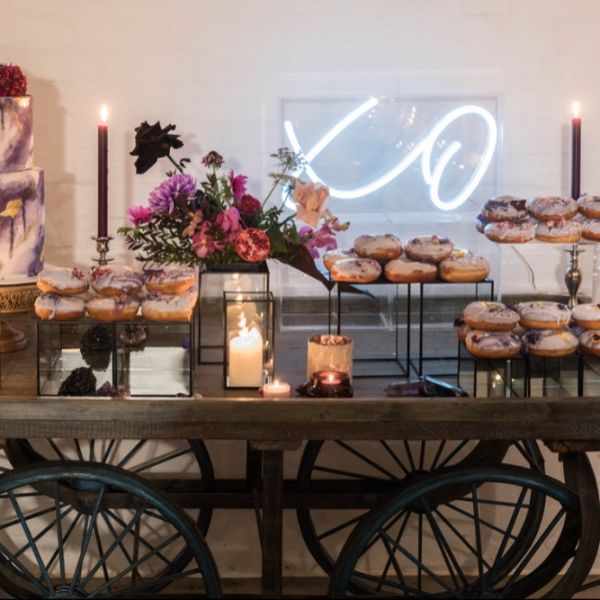 XO Light Up Sign in Acrylic Box shown as wedding decor behind the sweets table - from Custom Neon by Neon Collective