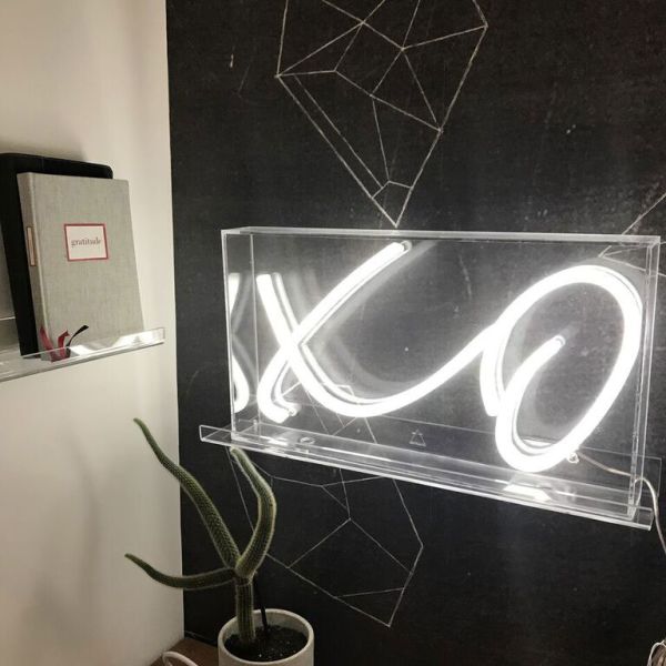 XO LED neon sign in acrylic box shown on a thin acrylic shelf as wall art - from Custom Neon by Neon Collective
