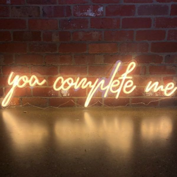 You Complete Me LED neon word light shown against a brick wall - Custom Neon®