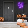 Purple neon cat light on black wall above Jack-o-lanterns at Halloween from Custom Neon®