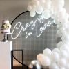 Crazy In Love Wedding Sign in brilliant LED neon flex shown in white with balloons and a wedding cake - photo from CustomNeon.co.uk