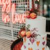 Crazy in Love LED neon wedding sign shown on mesh with a wedding cake in the foreground - photo from CustomNeon.co.uk
