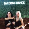 EAT DRINK DANCE Portable LED Neon Light Sign shown on a green wall at an Event - photo from CustomNeon.co.uk