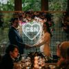 Beautiful LED neon heart light personalised with the bride & groom's initials. Shown here on a mesh background during the wedding reception - Custom Neon UK