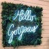 Hello Gorgeous light sign hung on a green wall in a beauty salon - Custom Neon
