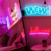 WOW faux neon sign against a white panelled bedroom wall from Custom Neon®