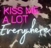 Kiss Me A Lot Everywhere LED Neon Sign in pink and white shown on faux cow hide - photo CustomNeon.com.au
