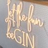 Let the Fun beGIN large neon sign - shown attached to the front of a gin bar at an event - photo from CustomNeon.co.uk