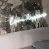 Love Happens LED Neon Light shown above bed against distressed wall - photo from Custom Neon®