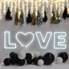 LOVE with a heart LED neon sign on brick wall with fairy lights - photo CustomNeon.co.uk