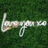 Love You XO LED neon light shown on a green wall - photo CustomNeon.co.uk