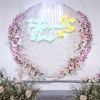 To the Moon & Back neon sign with a moon & stars surrounded by wedding flowers - designed by Custom Neon