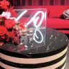 XO tabletop LED neon sign in acrylic box shown on a table during an event - from Custom Neon by Neon Collective