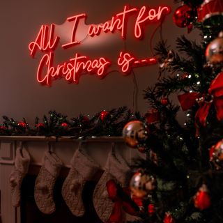 Custom Neon® red All I Want for Christmas sign next to a Christmas tree