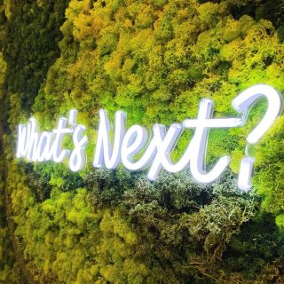 What's Next white Custom Neon® sign on faux moss wall @artandassoc