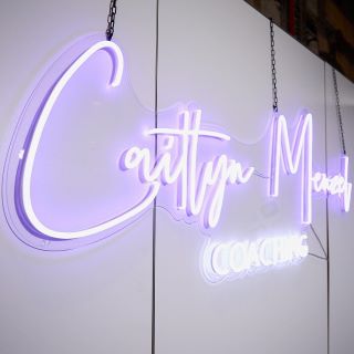 Custom Neon® purple hanging tradeshow booth sign @caitlynmenzelcoaching