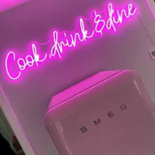 Pink Custom Neon® Cook Drink & Wine sign above a Smeg fridge