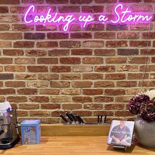 Pink Custom Neon® Cooking Up a Storm sign on brick wall @martin.whitehouse.life