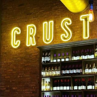 Orange Custom Neon® restaurant sign on brick wall @crust_pizza