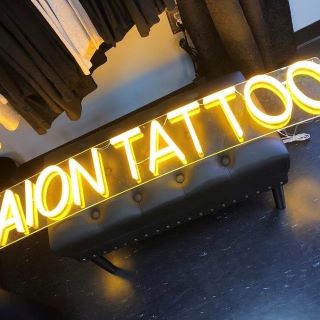 Yellow window sign made by Custom Neon® for @aiontattoo