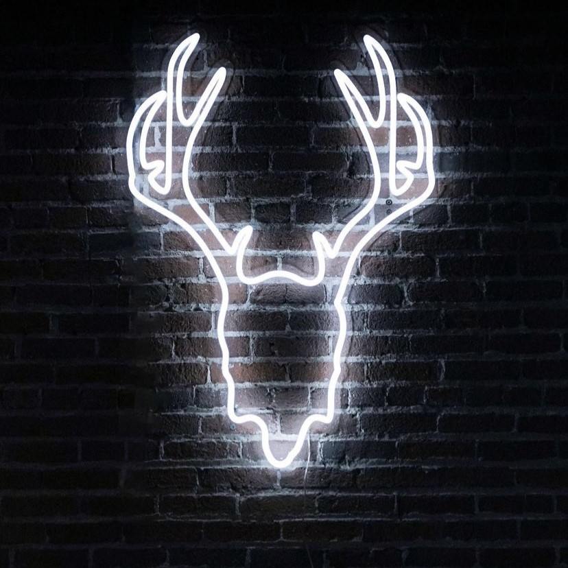 Custom Neon® white deer head sign on dark brick wall @madrabbit