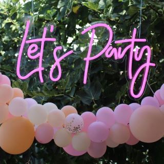 Custom Neon® Let's Party in pink suspended from trees at a garden party