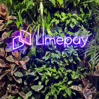 Purple logo on living green wall @limepayments made by Custom Neon®