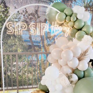 Custom Neon® party bar sign on meshed arch surrounded by balloons