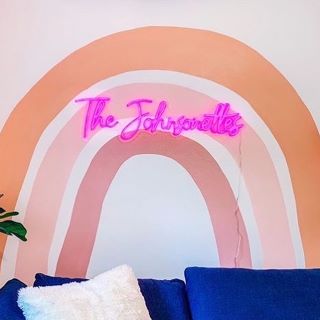Pink Custom Neon® family name sign on living room wall