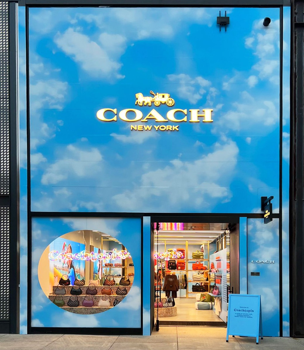 Coachtopia no-waste logo signs made by Custom Neon® in the storefront window at Coach New York
